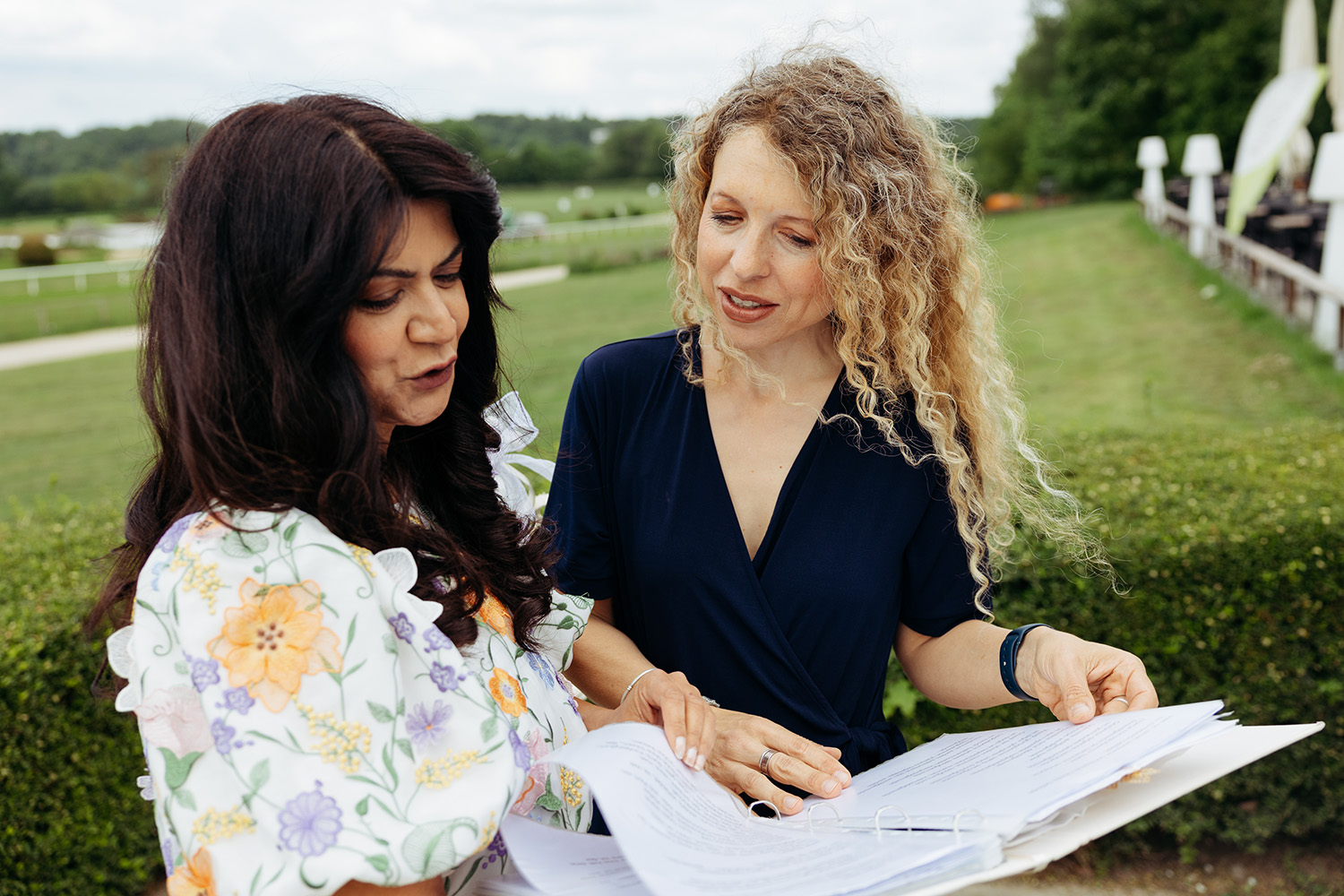 Hochzeitsplanerin im Gespräch mit Traurednerin auf der Wiese – Trauungsablauf besprechen – Hochzeitsplaner Mettmann