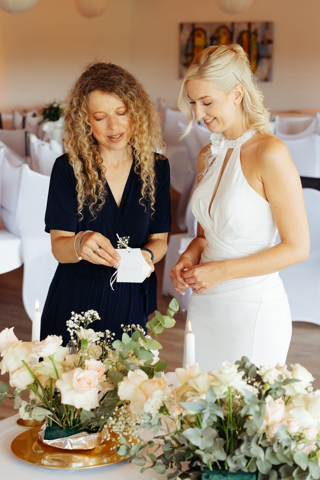 Hochzeitsplanerin aus Düsseldorf berät die Braut bei der Tischdekoration mit Rosen und Kerzen